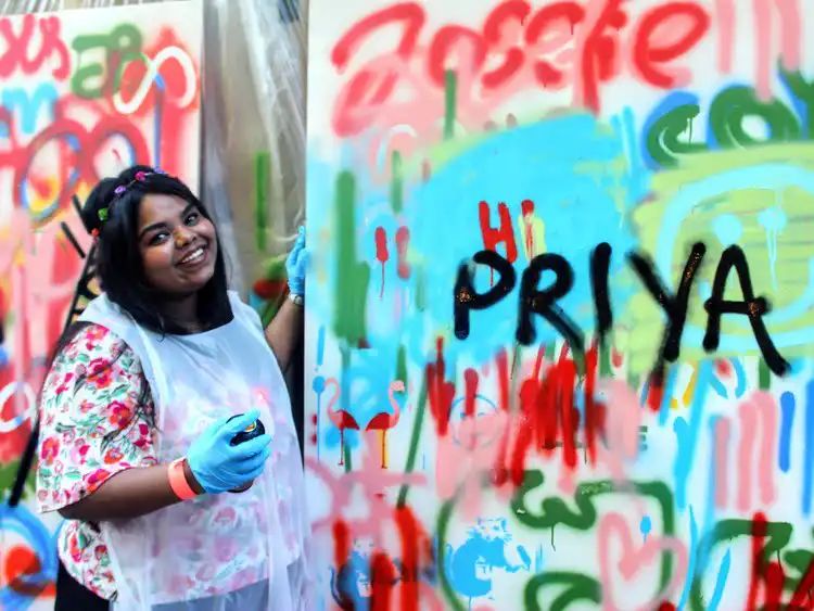 Guests painting sections of a collaborative mural at a team event