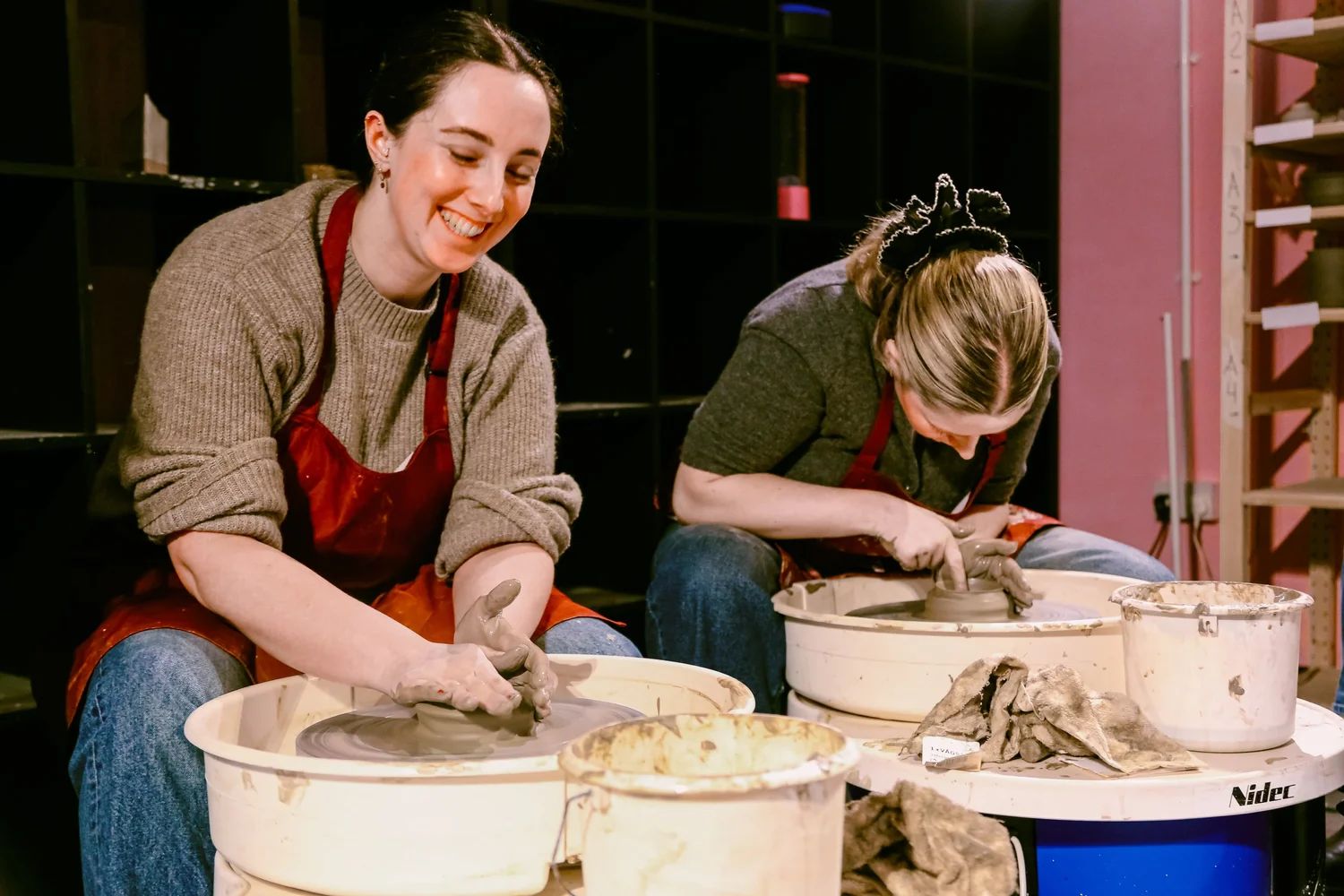 Guest shaping clay at a pottery studio table