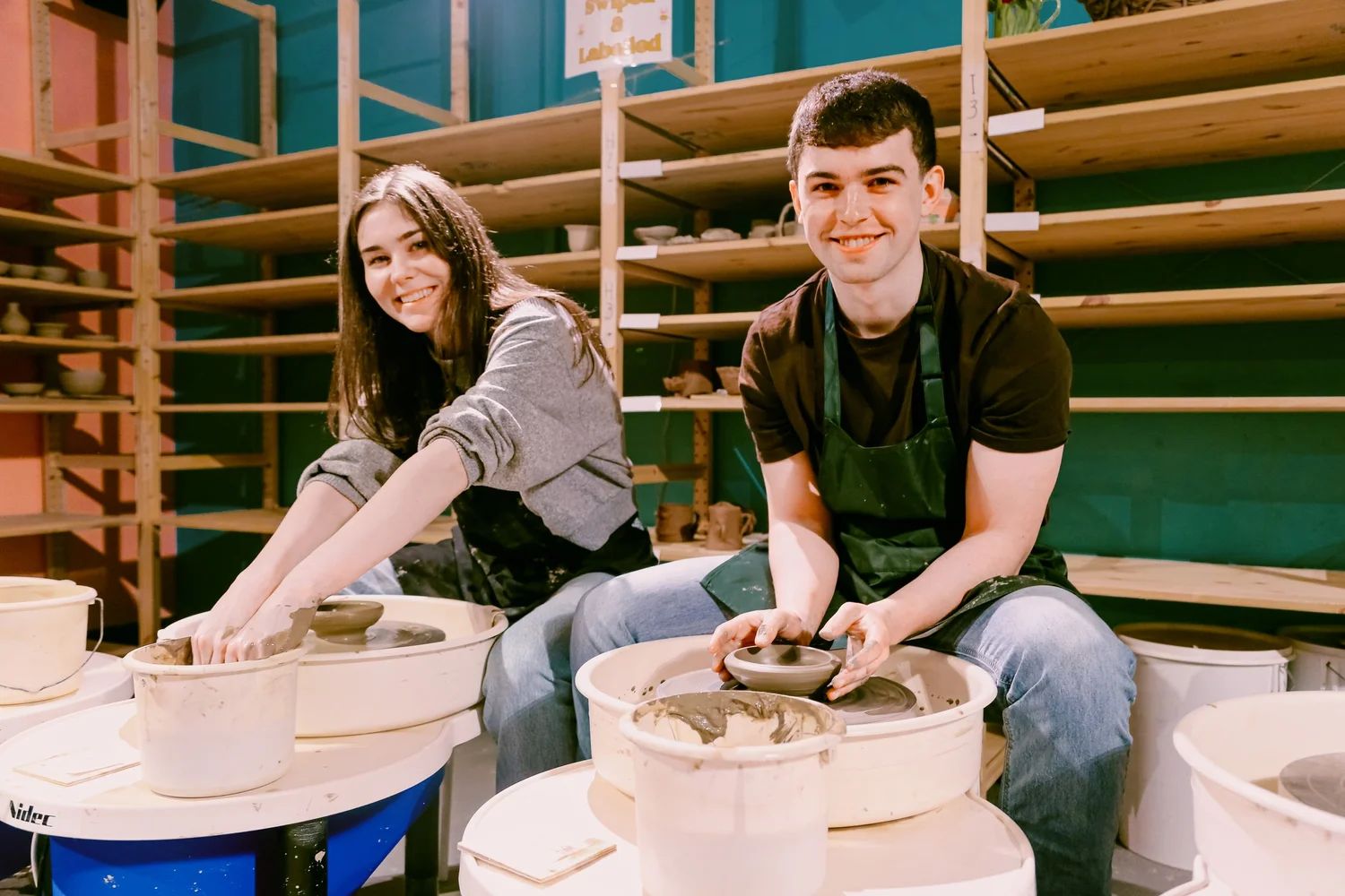 Hands working on a clay pottery piece during a workshop
