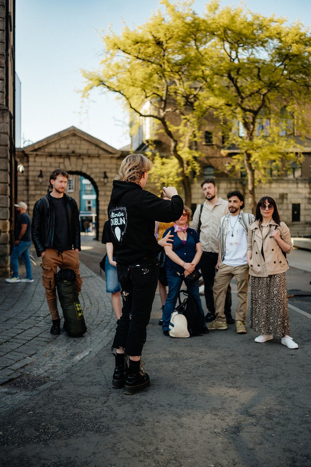 Group of guests listening attentively to their guide in an outdoor stone courtyard