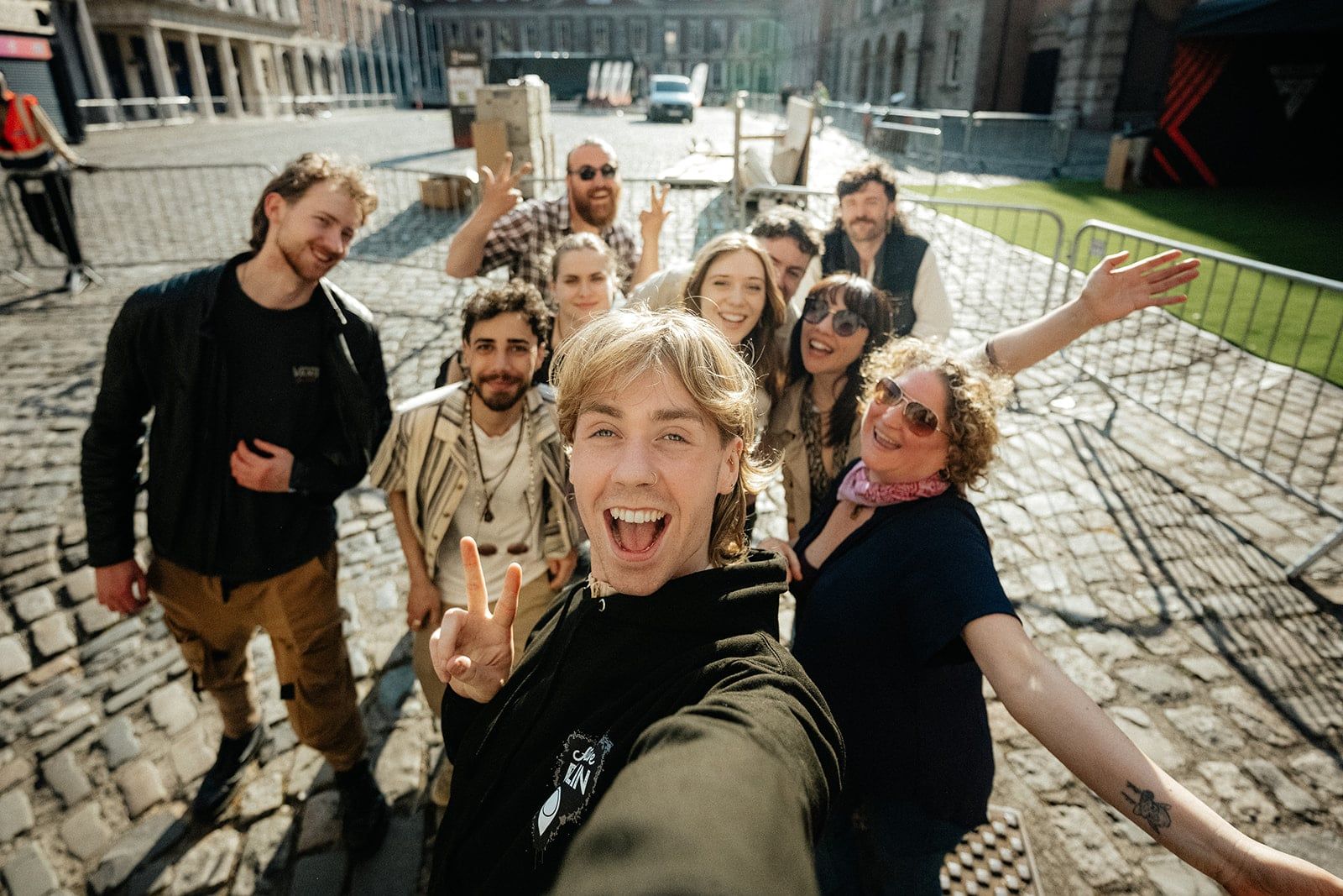 Guide taking a group selfie with smiling tour guests in an outdoor courtyard
