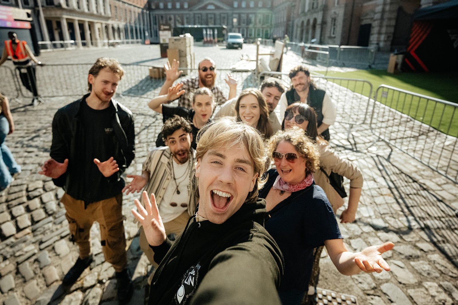 Guide taking a fun group selfie with guests cheering during a walking tour