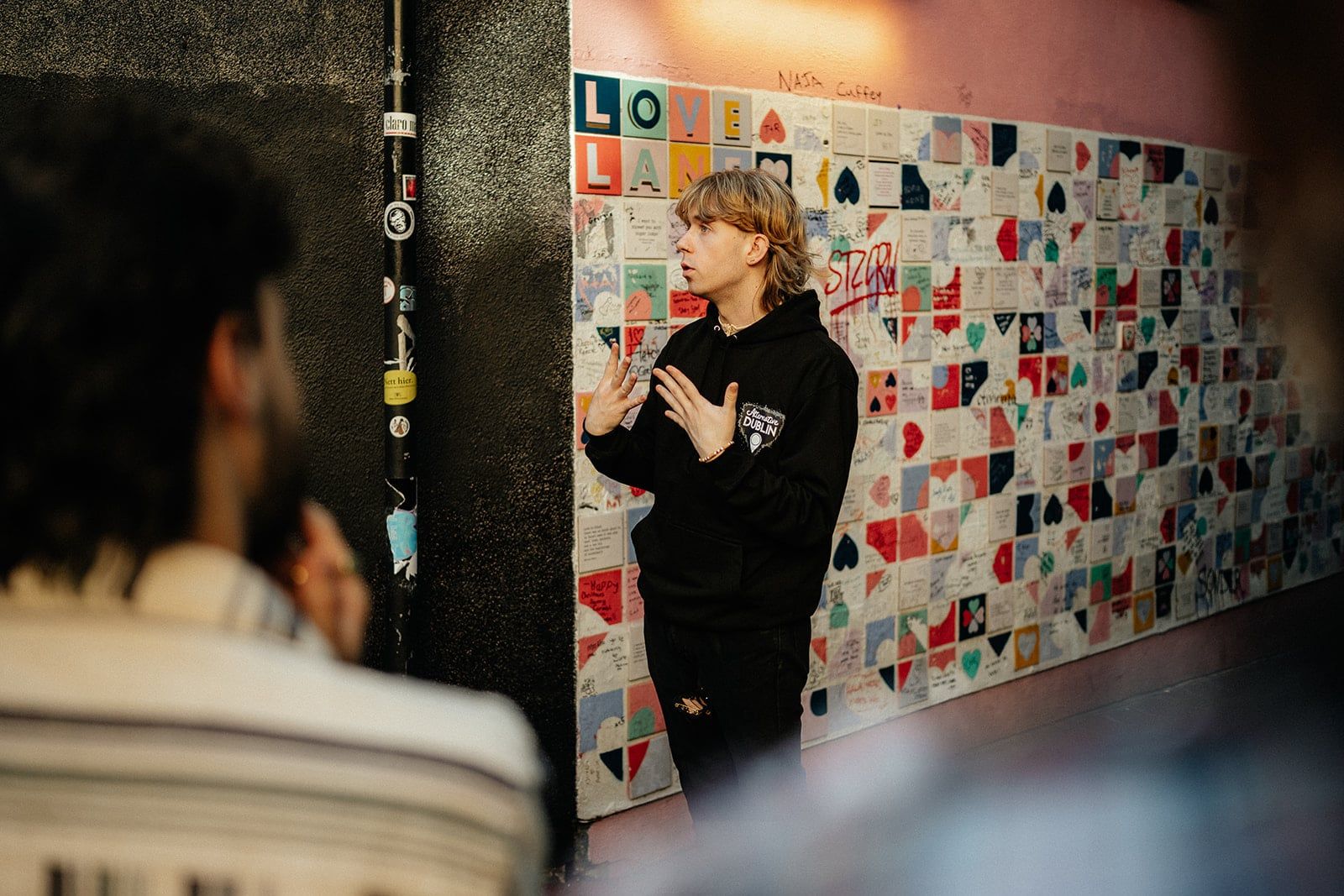 Guide speaking in front of a wall covered in small colorful notes