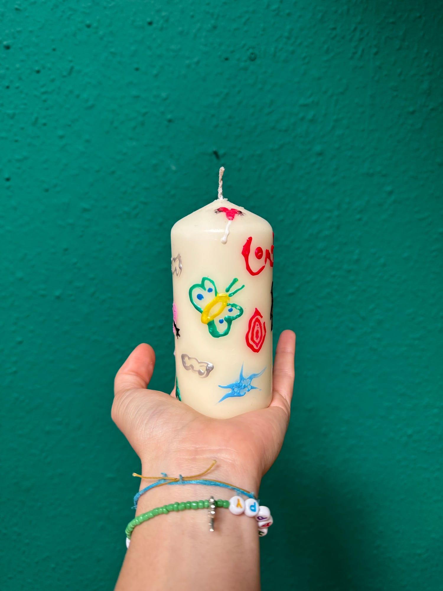 Finished candle featuring a painted ghost from a candle painting event
