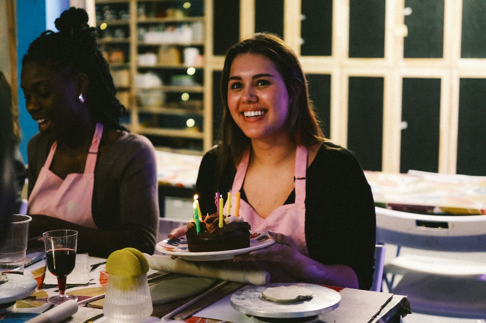 Smiling guest holding a small slice of cake on a plate at a pottery event