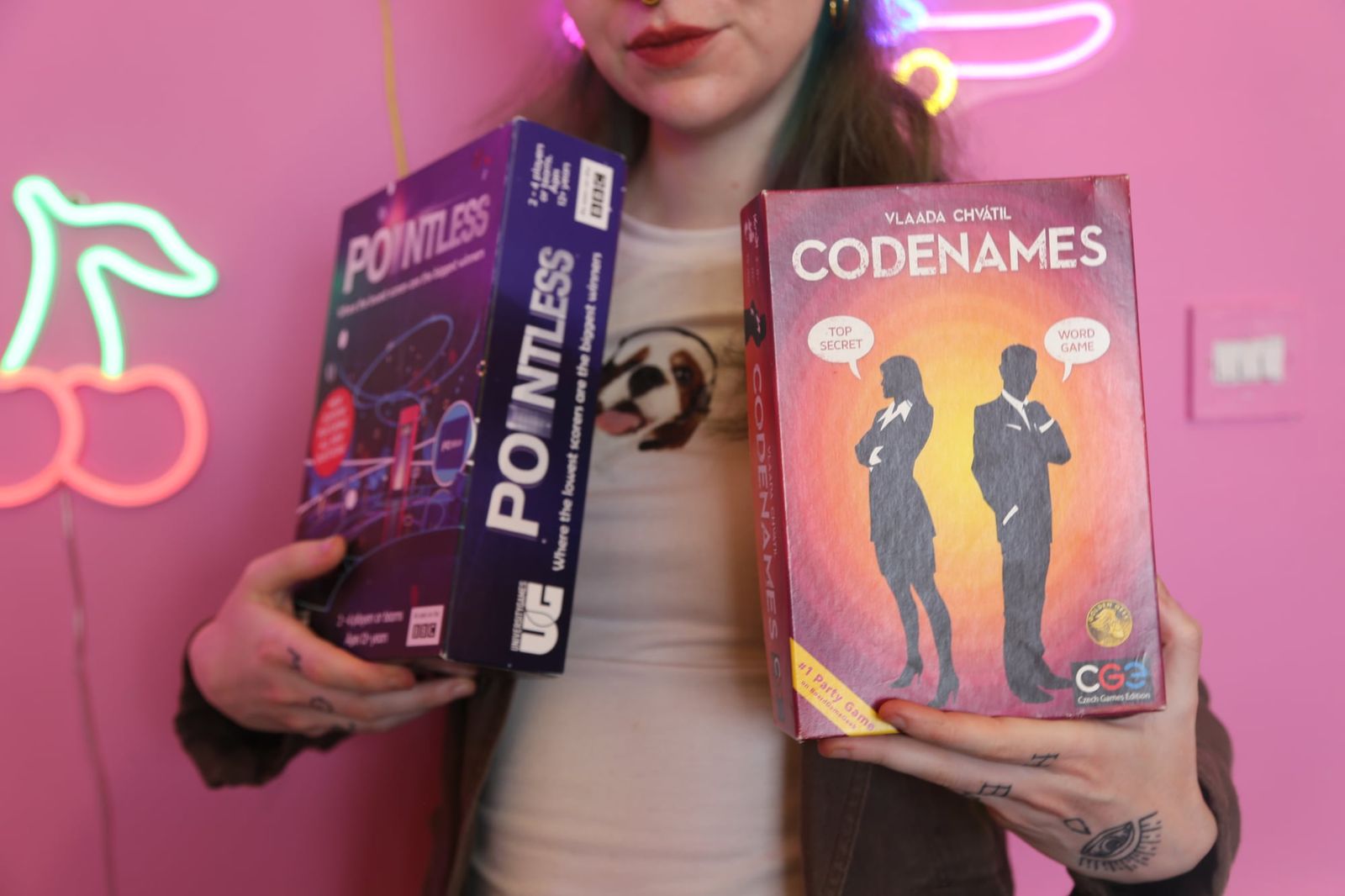 Guest holding up board game boxes at a games event