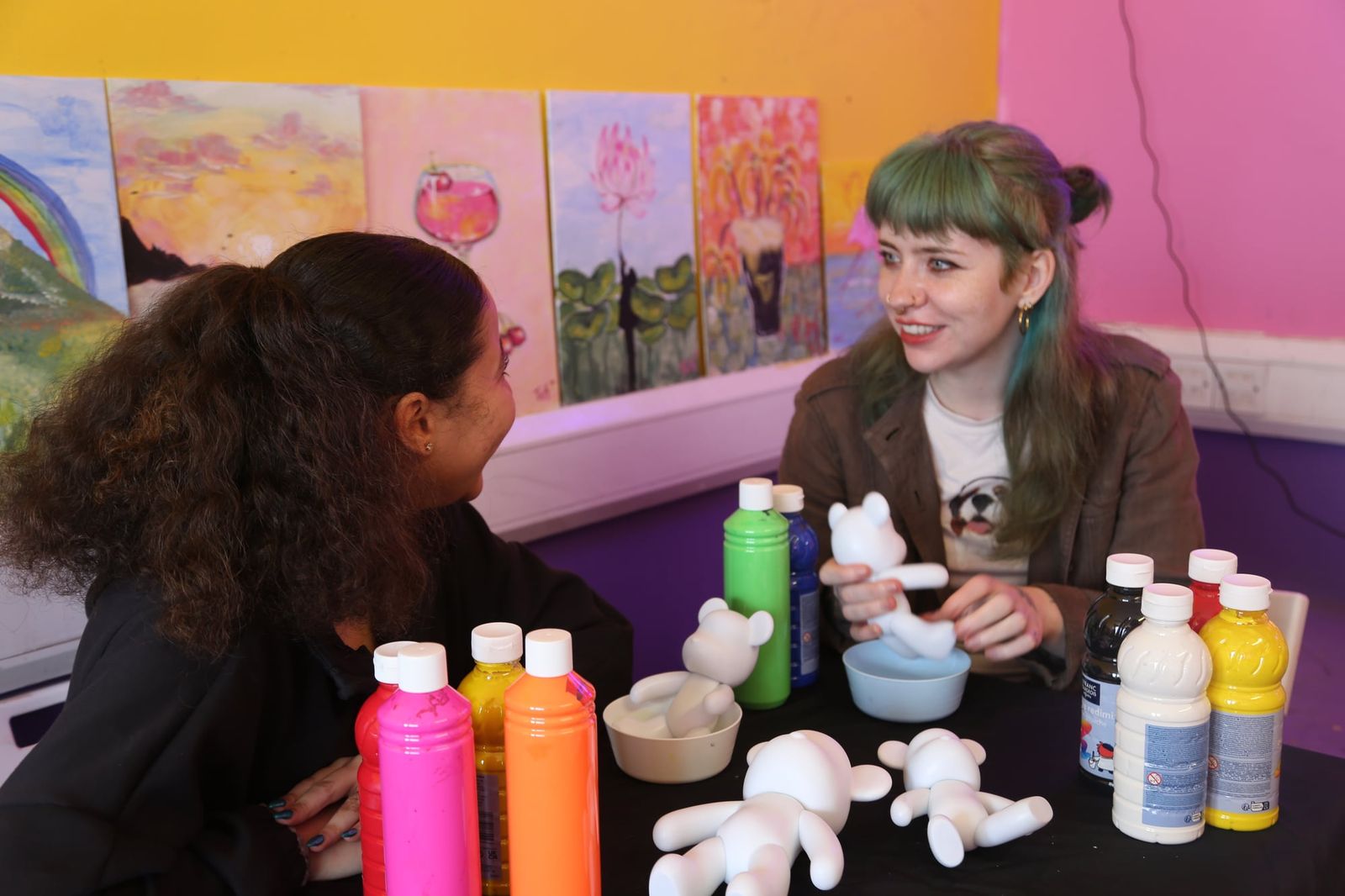 Two women chatting while preparing to paint at a bear pouring class